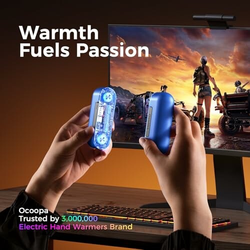 Person holding electric hand warmers in front of a gaming monitor.