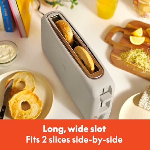 Toaster with two bagel slices in a long, wide slot.