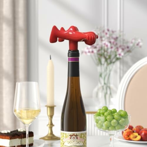 Wine bottle with quirky corkscrew on elegant dining table with desserts and fruits